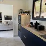 Cuisine double linéaire à l’Anse à l’Âne : façades bleu roi, plan de travail compact et agencement pensé pour la location saisonnière.