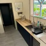 Cuisine double linéaire à l’Anse à l’Âne : façades bleu roi, plan de travail compact et agencement pensé pour la location saisonnière.