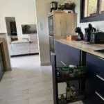 Cuisine double linéaire à l’Anse à l’Âne : façades bleu roi, plan de travail compact et agencement pensé pour la location saisonnière.