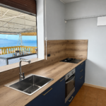 Cuisine moderne Bleu Cosmique avec évier, four intégré et plan de travail bois en Martinique